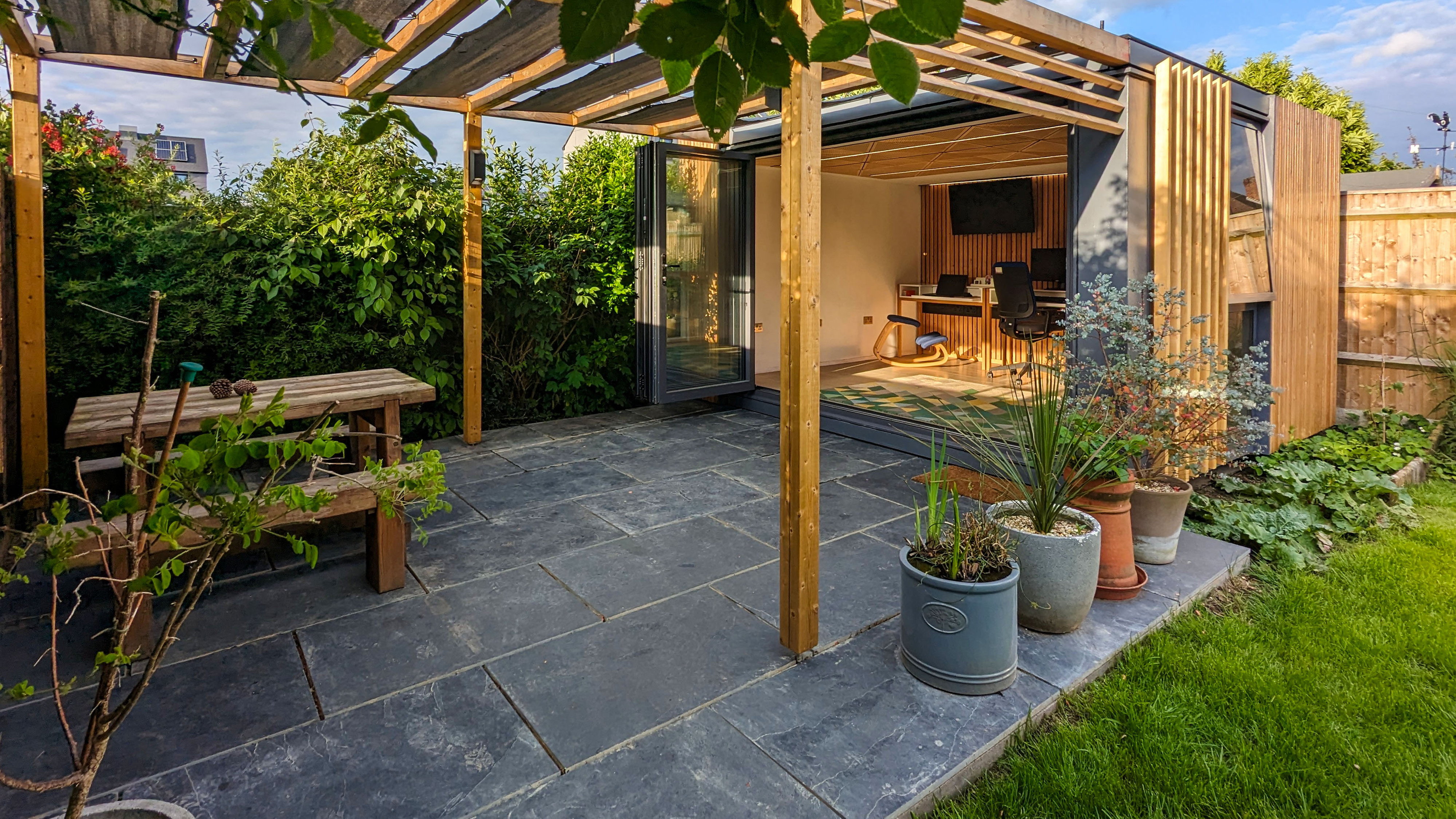 Next to the office, Graham and Sarah have created a shaded terrace with a bench for social gatherings.