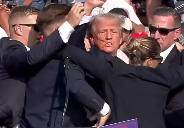 Trump appears to have been shot in the ear and has blood running down his face during a rally in Pennsylvania