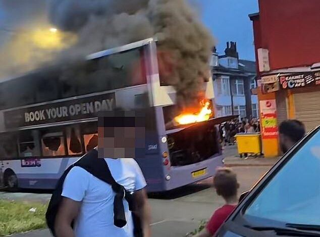 Rioters set fire to bus and vandalise police car on shameful night in Leeds: Residents are asked to stay indoors as huge crowds tear through streets after confrontation with dozens of officers