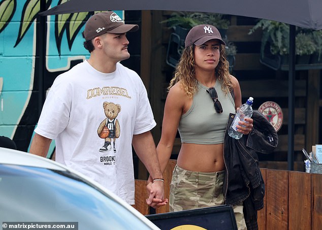 Mary Fowler wears camouflage trousers and a crop top as she walks hand-in-hand with Nathan Cleary at a local market – after the Penrith star was hit hard