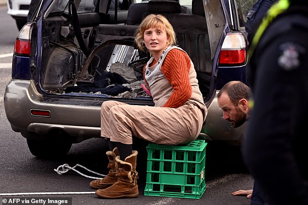 Young woman cements herself to a car during the third and final day of anti-war protests in Melbourne