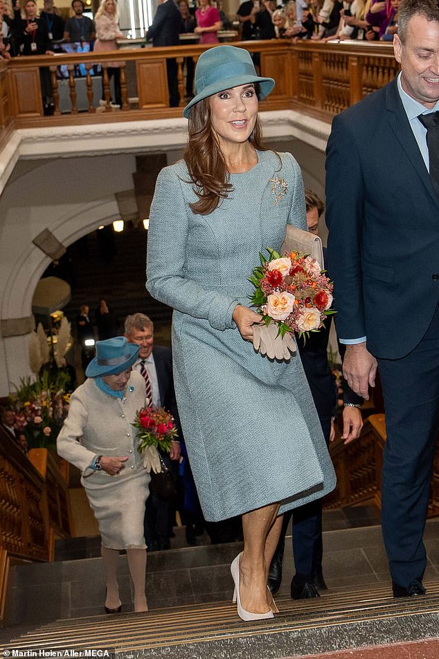 Queen Mary of Denmark beams in cool green as she attends the opening of Parliament with King Frederik