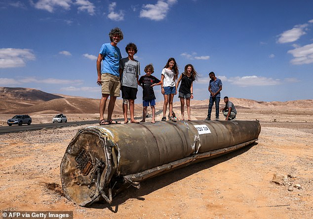 Rebellious children play on wrecked rocket in Israeli desert – as IDF prepares to attack Iranian nuclear sites ‘within days’