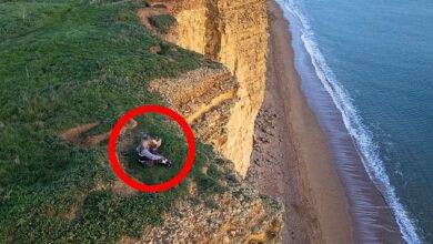 The height of stupidity! Two women risk their lives as they sit on the edge of a crumbling 160-foot cliff and watch the sunset, just weeks after the great rockfall